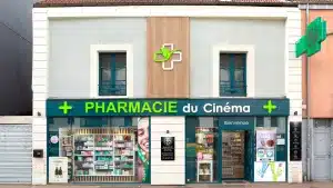 Vue d'ensemble de la Pharmacie du Cinéma, montrant l'enseigne lumineuse et la façade rénovée.